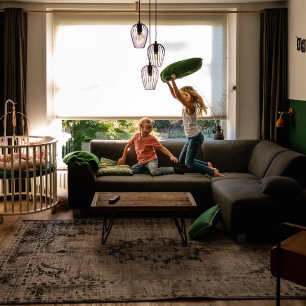 Newborn reportage in Woudrichem, kussengevecht tussen zus en broer, foto door Sandra Stokmans Fotografie