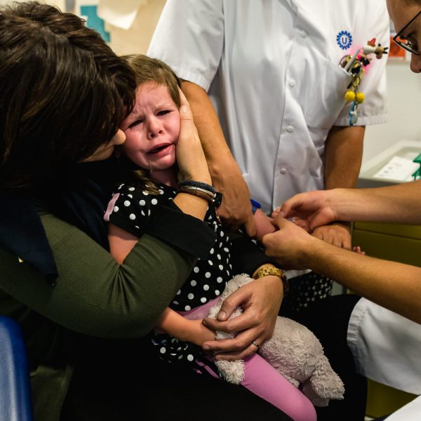 Mama troost tijdens dat dochter geprikt wordt, Hartekind met syndroom Williams-Beuren, foto door Sandra Stokmans Fotografie