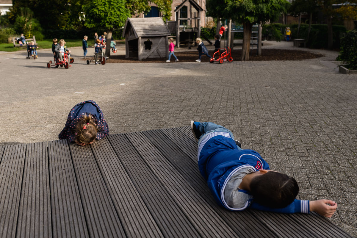 Verstoppertje spelen tijdens de pauze op school tijdens Day in the Life Rotterdam voor Project Hartekind, foto door Sandra Stokmans Fotografie
