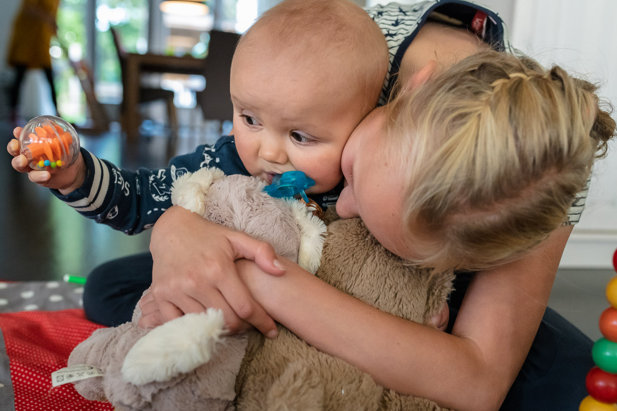 Tijdens deze fotosessie van groot gezin, krijgt kleine Jens dikke vette knuffels van zijn grote zus. Familie fotografie, Sandra Stokmans Fotografie