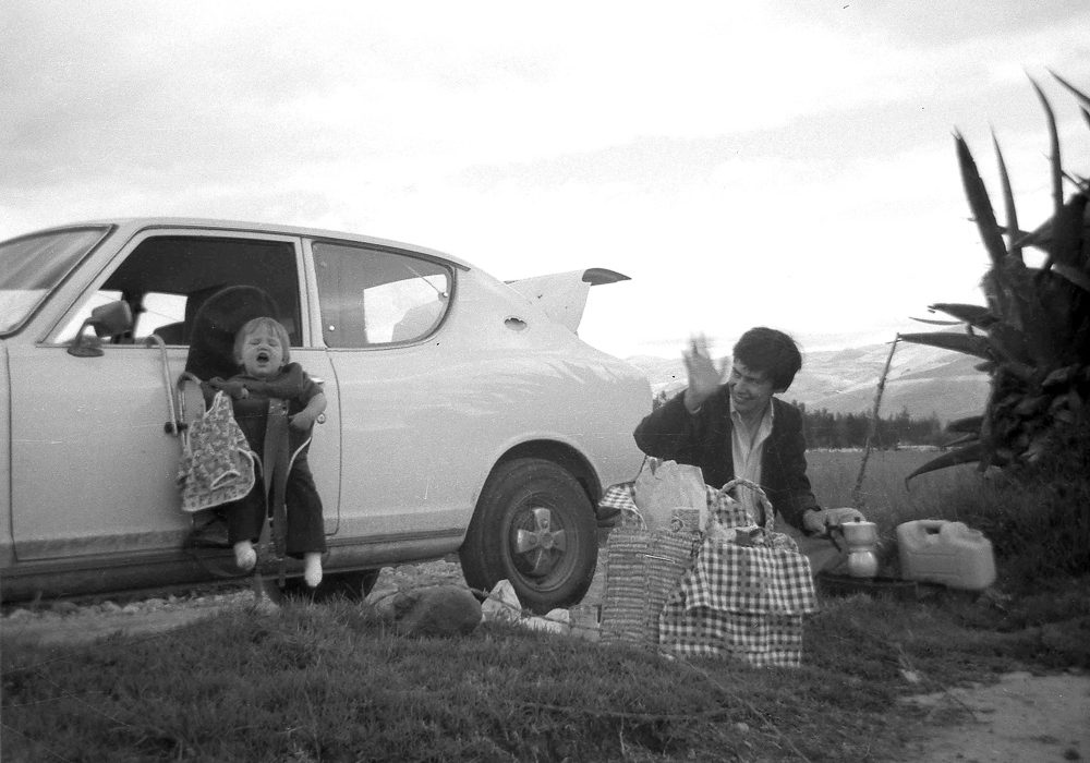 Sandra Stokmans als baby, picknick Peru, kind hangend aan autodeur